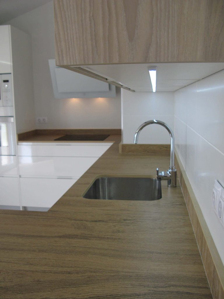 Cocina en blanco y meadera con encimera simulación madera en Dekton Valterra