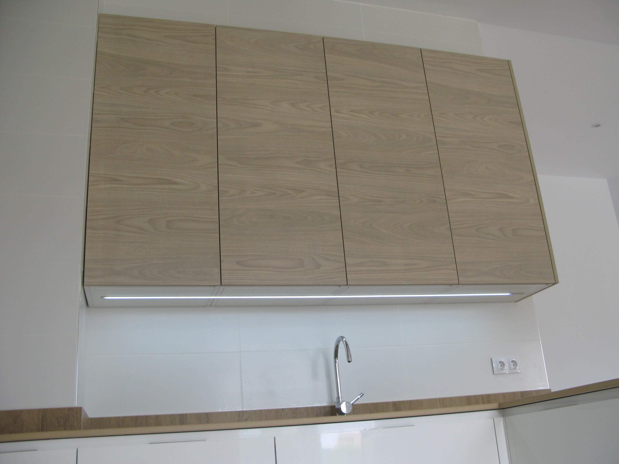 cocina en blanco y meadera con encimera simulación madera en Dekton Valterra
