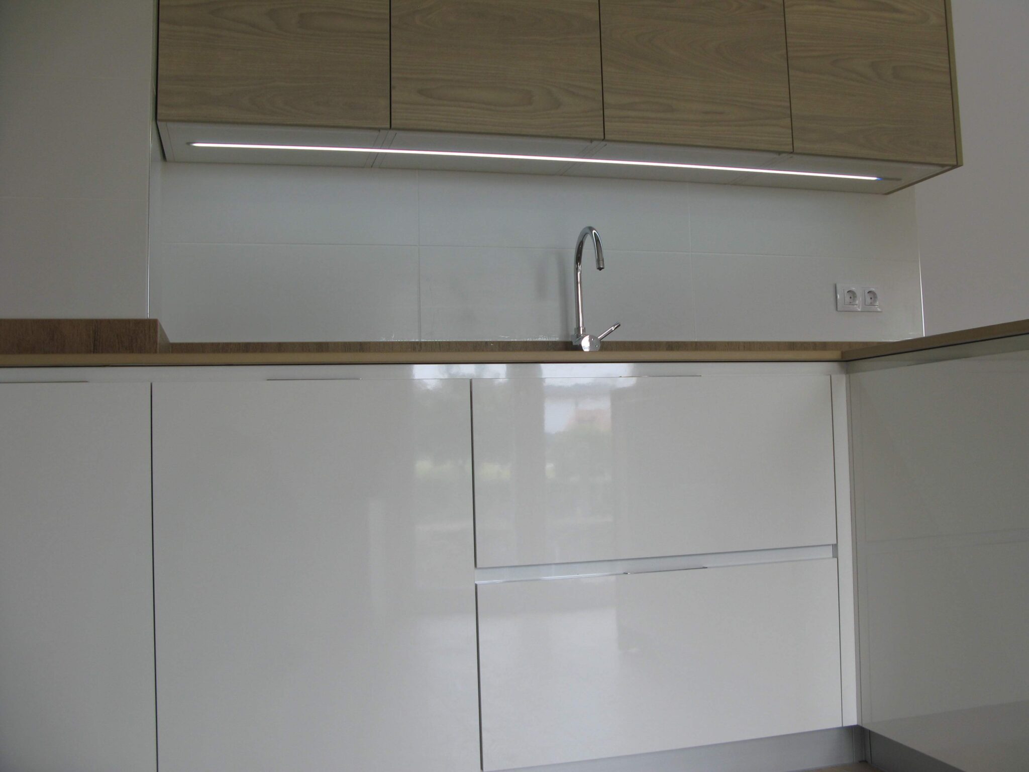 cocina en blanco y meadera con encimera simulación madera en Dekton Valterra
