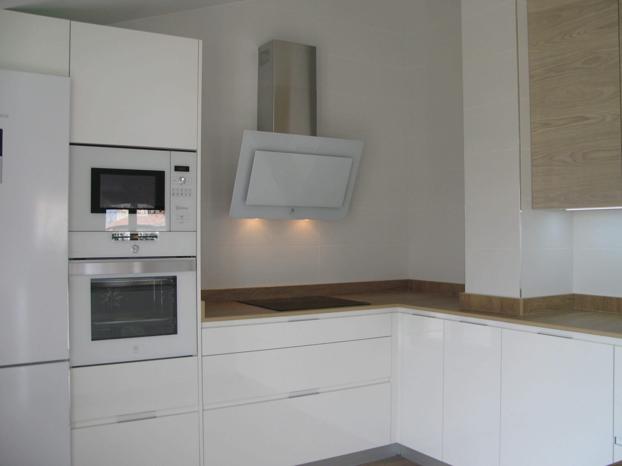 cocina en blanco y meadera con encimera simulación madera en Dekton Valterra