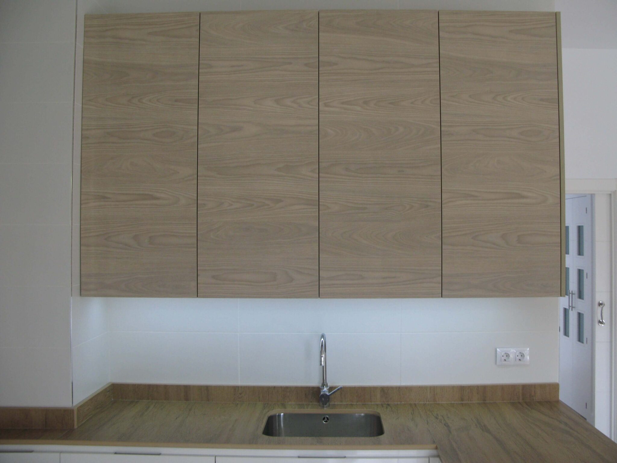 cocina en blanco y meadera con encimera simulación madera en Dekton Valterra