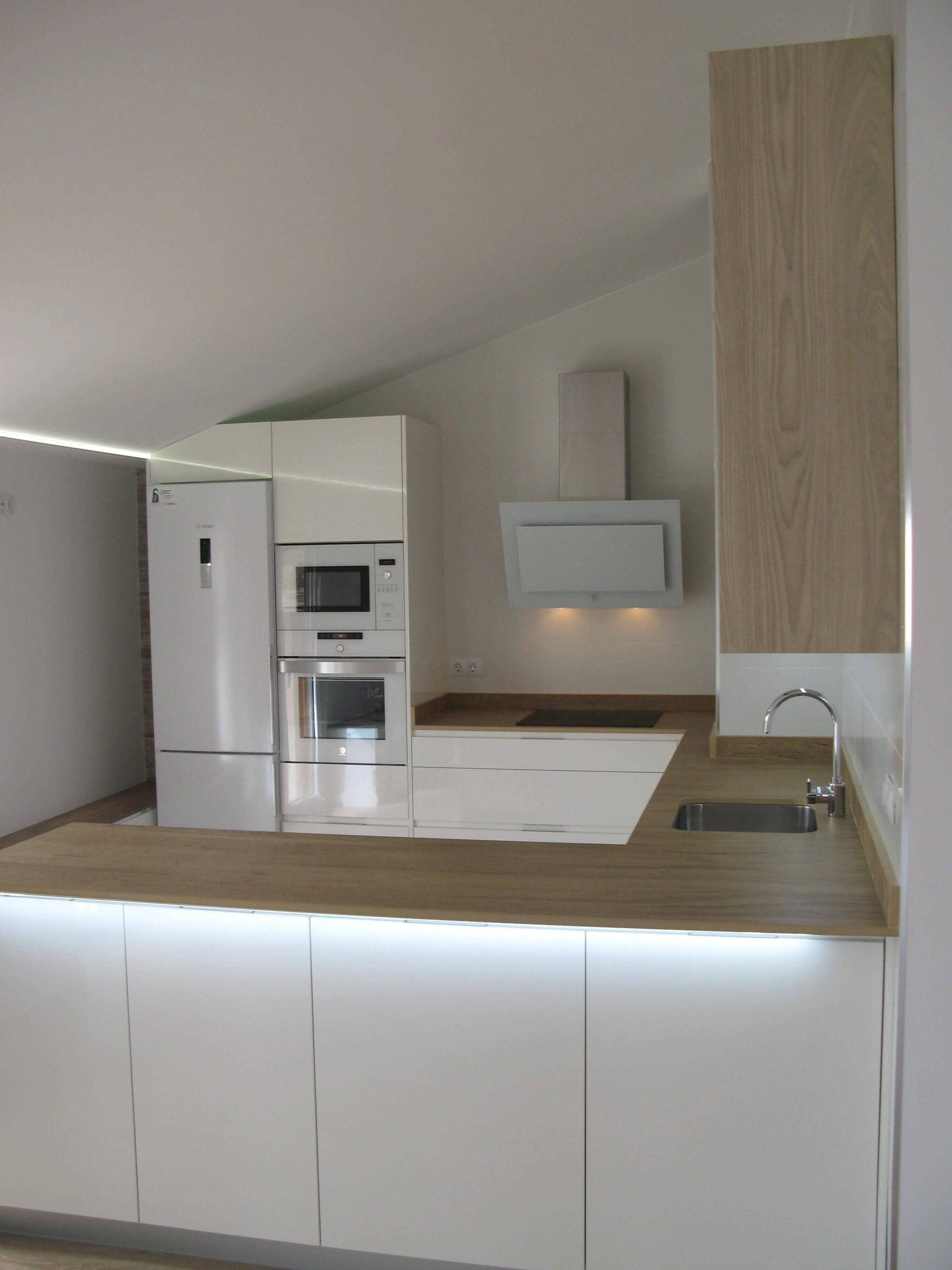 cocina en blanco y meadera con encimera simulación madera en Dekton Valterra